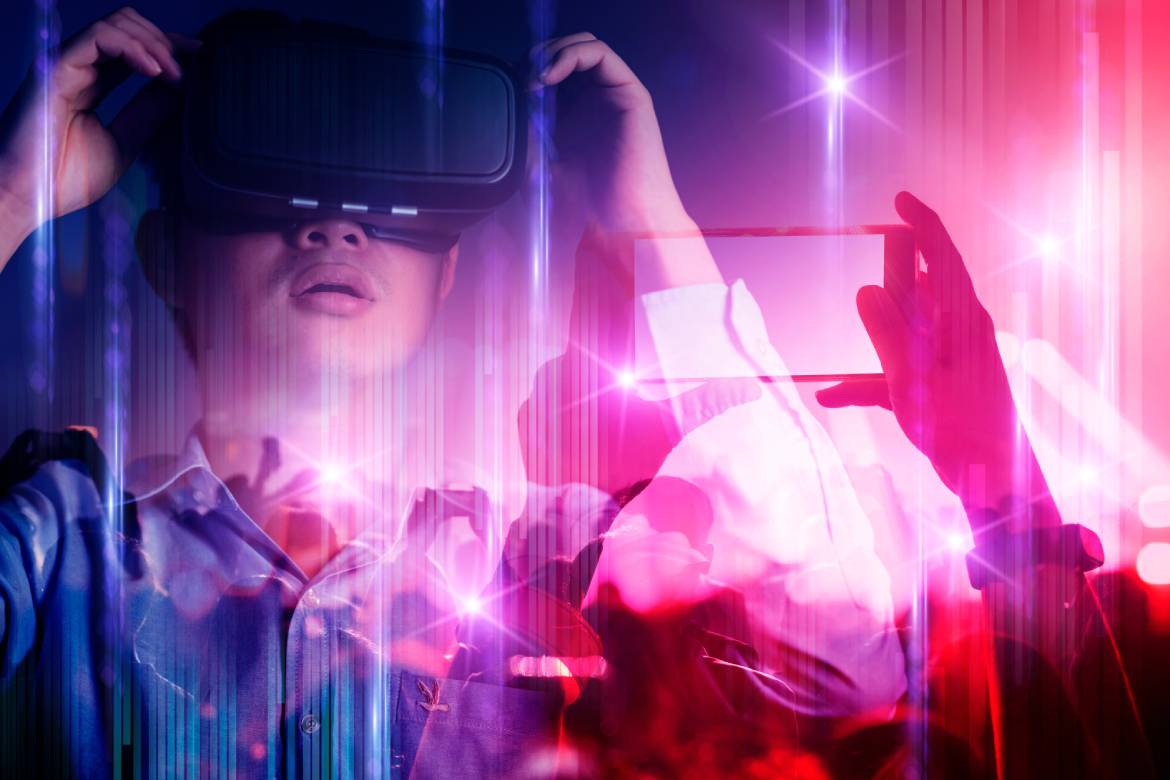 A young asian man wearing a vr headset experience the lights and crowd of a crowded event.