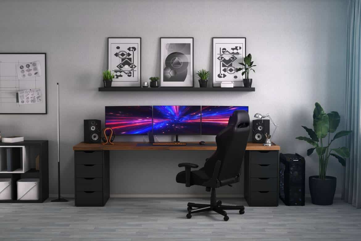 An open room for gaming with a wide desk, a triple-monitor gaming computer setup, and black-and-white décor items.