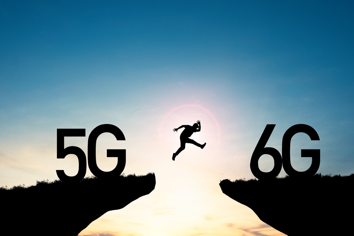 A person jumping from one cliff to another with large logos that say 5g and 6g. The person is jumping ontp the 6g side.