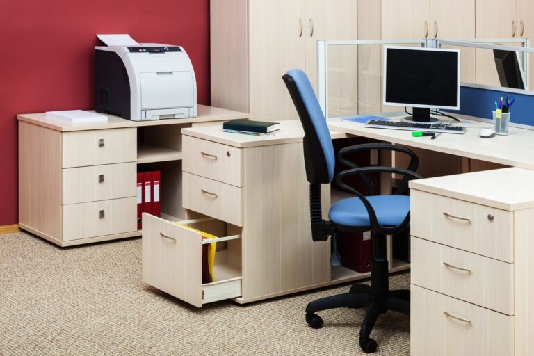 An organized office workspace featuring a desk, chair, several cabinets, a printer, and a desktop computer.