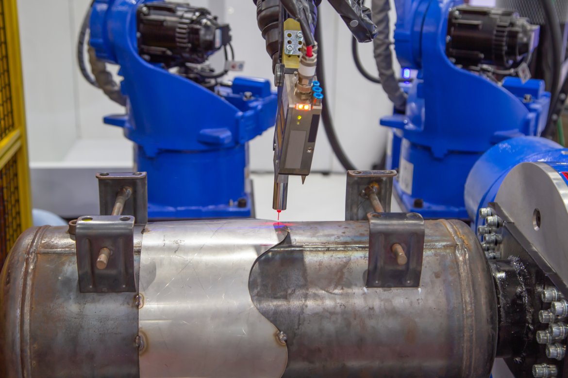 A laser tracker device etches on a rolling piece of metal as the machine moves. The laser is cutting a curved line.