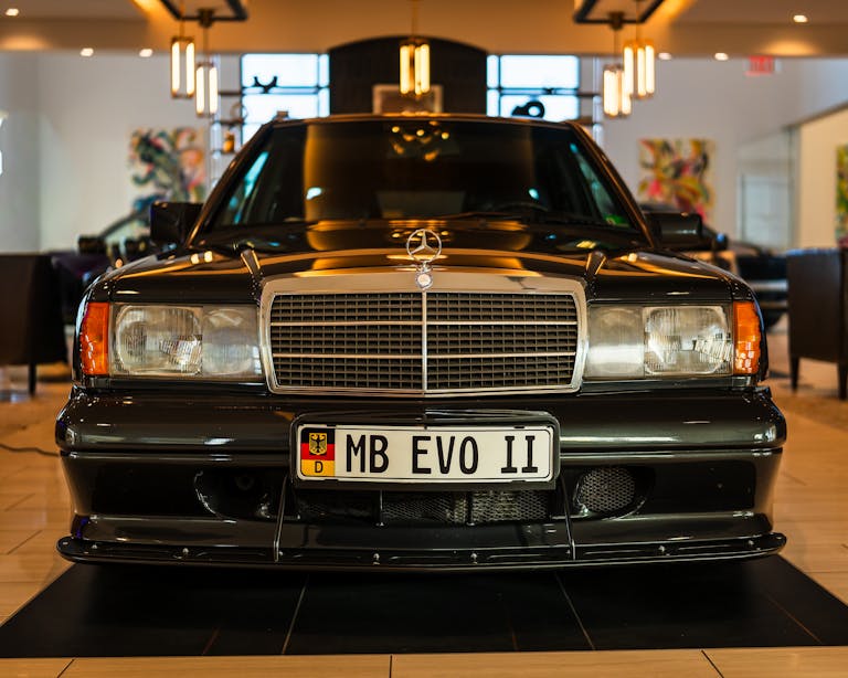 Front view of a luxury vehicle displayed elegantly in a showroom, highlighting its sleek design.