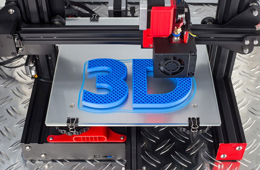 A close-up of an open-frame 3d printer printing the phrase "3d" in bright blue filament on a silver build plate.