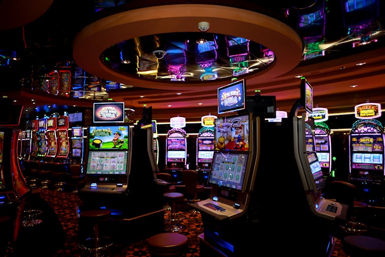 Vibrant casino floor with colorful slot machines and bright lights capturing a lively gaming atmosphere.