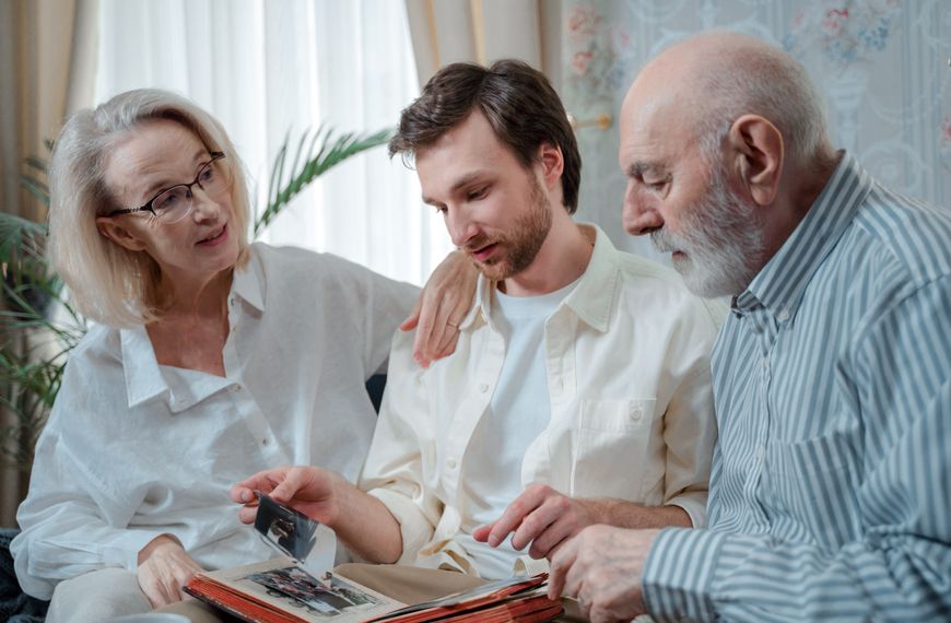 A family looks through a photo album, cherishing memories together indoors.