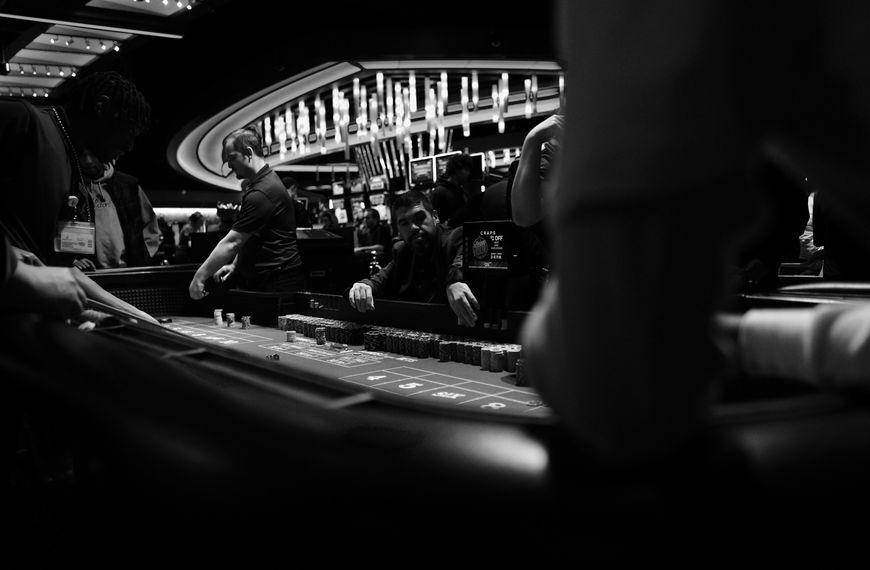 High-stakes gambling at a casino craps table in black and white.