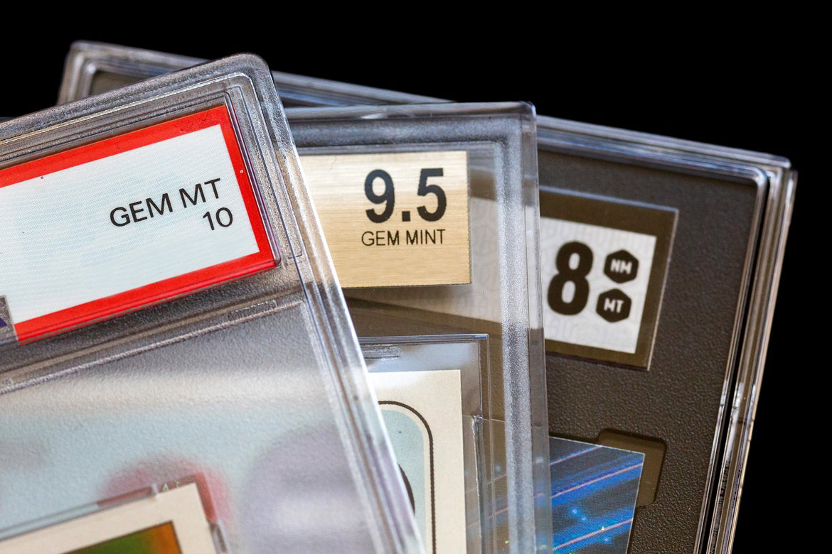 A group of graded trading cards in clear protective cases with labels reading gem mt 10, 9. 5 gem mint, and 8 nm mt.