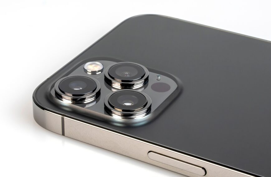 A close-up view shows an iphone with a silver edge and a black back that's lying screen side down.